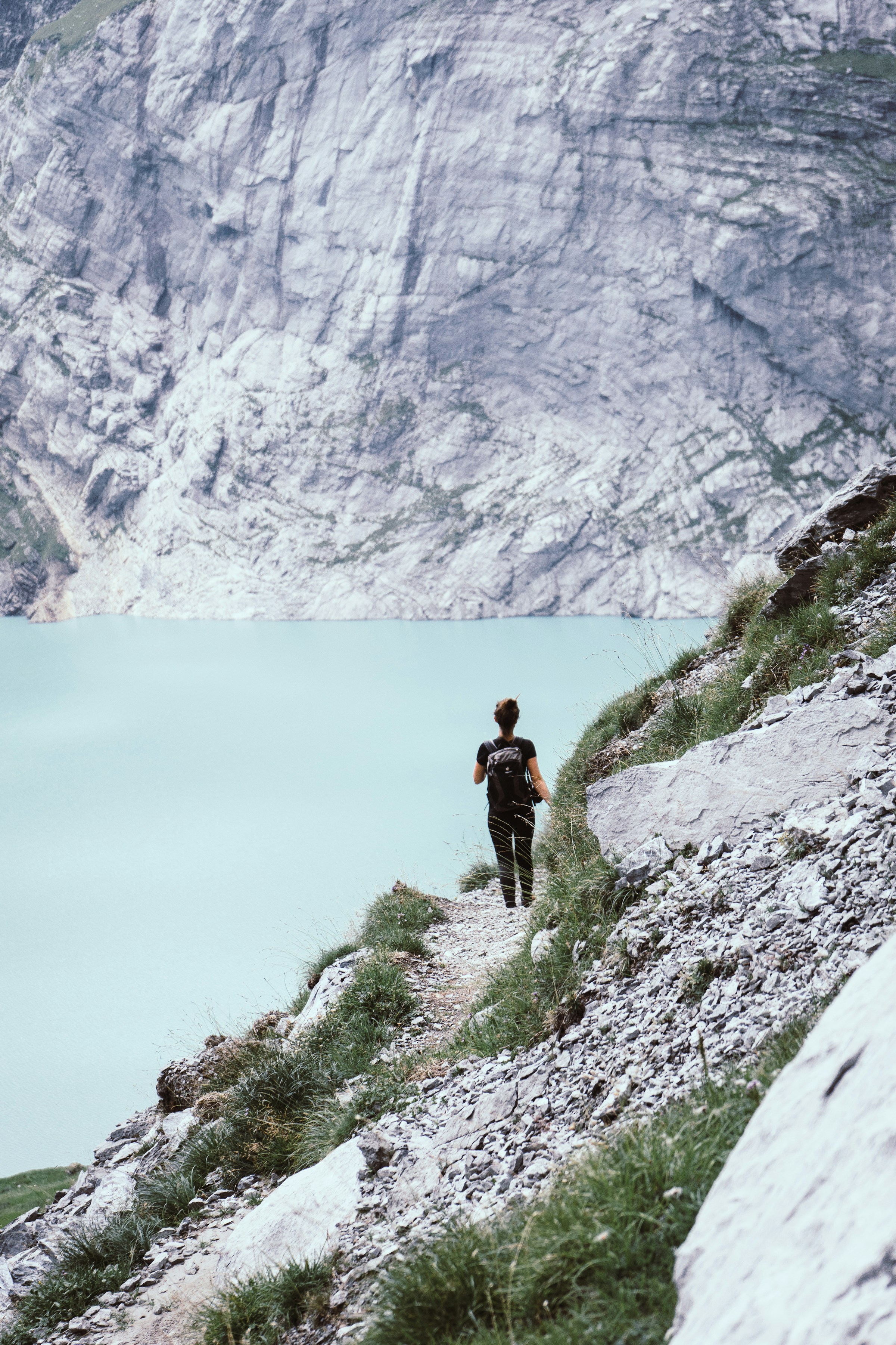 A backpacker overlooking a turquoise alpine lake